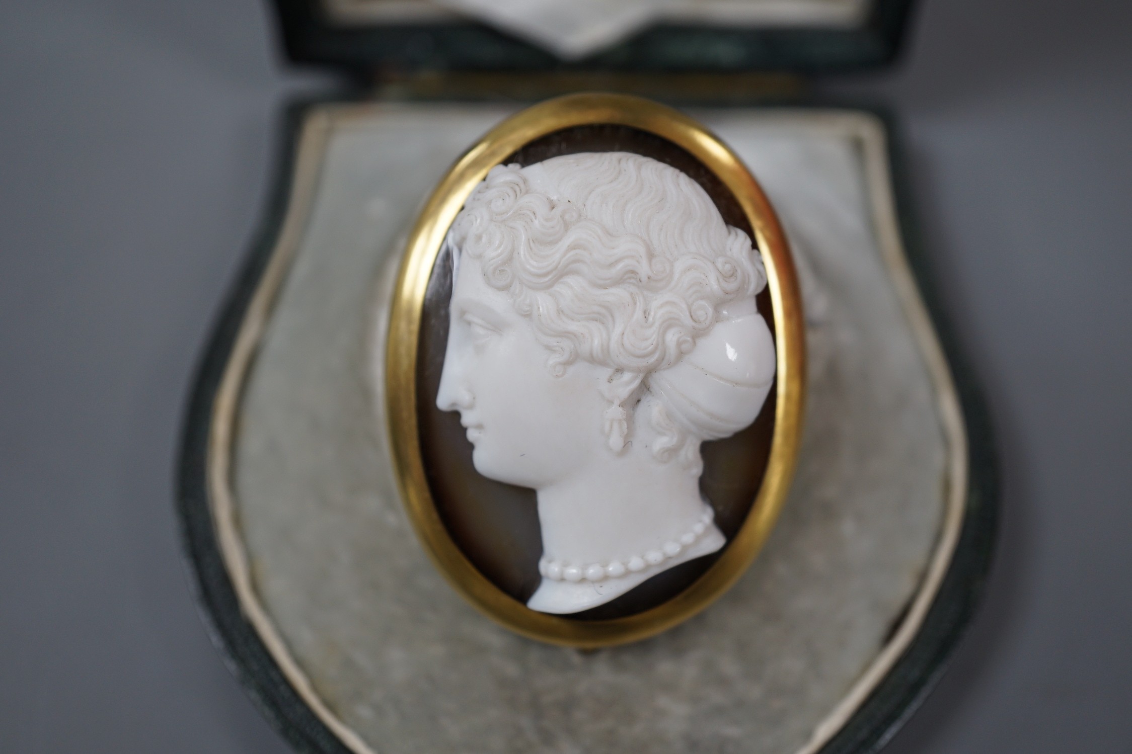 A Victorian yellow metal mounted agate cameo oval brooch, carved with the head of a lady to dexter, 41mm, in fitted initialled leather case.